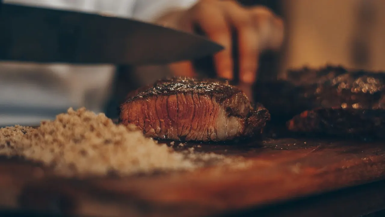 A butcher at work preparing meat at a clean counter