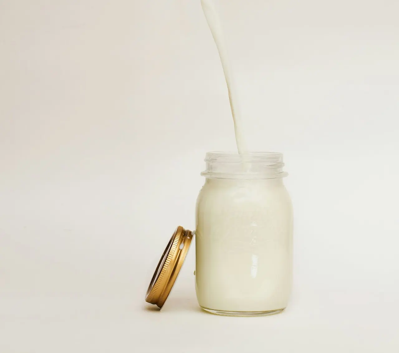 Fresh milk being poured in a dairy production setting